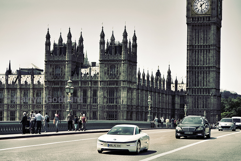 VW XL1 extended range prototype vehicle (282 mpg.) Nick Mason of the Pink Floyd on demonstration drive over Westminster Bridge london UK.
